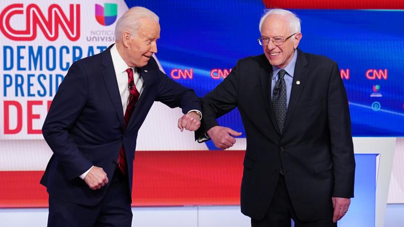 Democratic presidential hopefuls former US vice president Joe Biden (L) and Senator Bernie Sanders (R) greet each other with an elbow bump as they arrive at Sunday's Democratic debate in Washington, D.C.