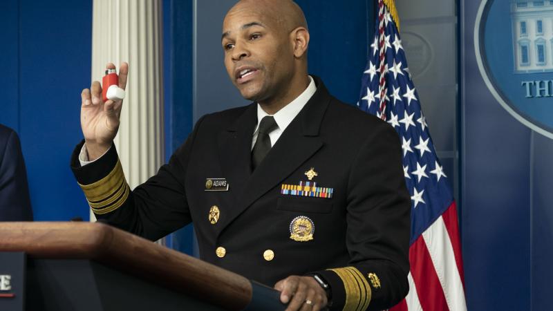United States Surgeon General Dr. Jerome Adams holds up his inhaler as he delivers remarks during a coronavirus update briefing Friday, April 10, 2020, in the James S. Brady Press Briefing Room of the White House.