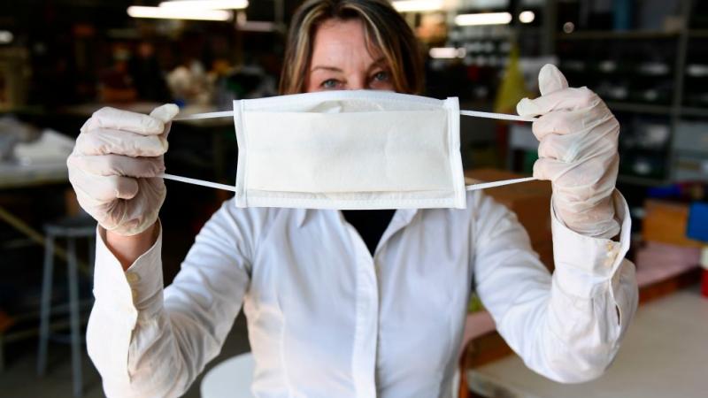 An employee at a leather workshop that has been turned into a mask factory in Italy