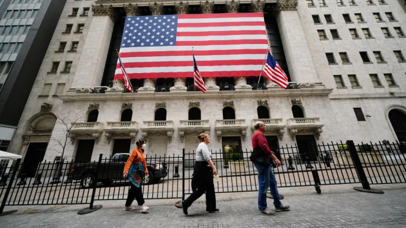 People walking past New York Stock Exchange on April 5, 2020