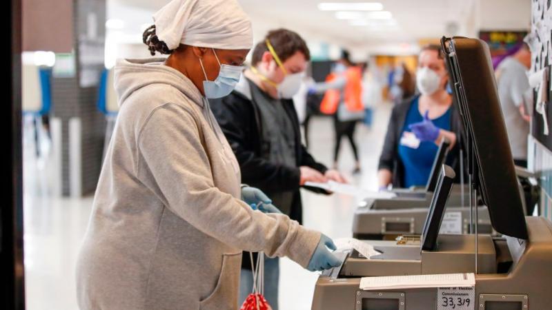 A woman casts her vote in the Wisconsin presidential primary election on April 7, 2020