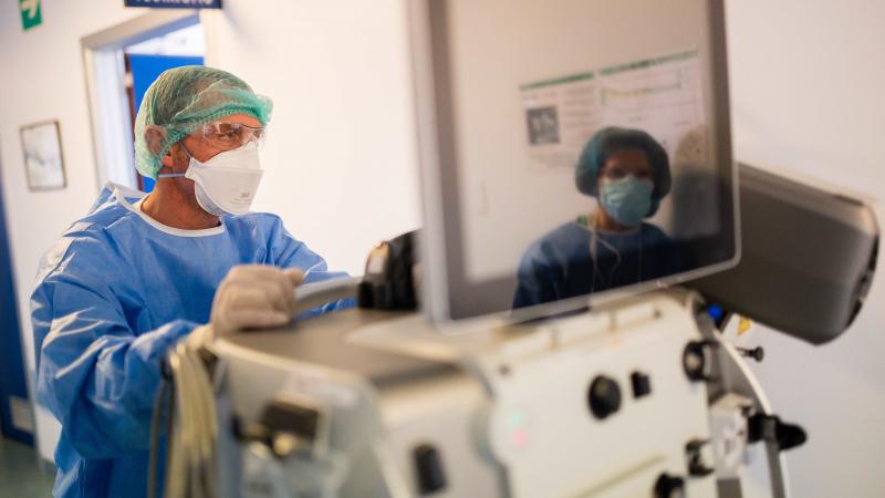 A doctor pushes a ventilator.