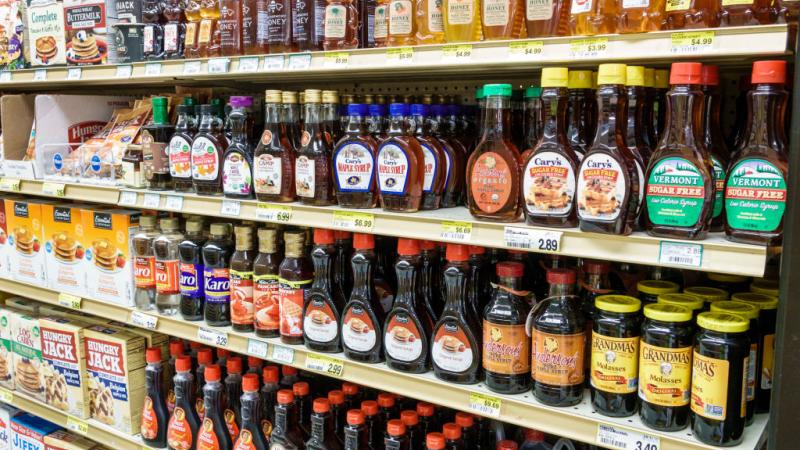 Grocery store shelves lined with syrup brands, including the soon-to-be discontinued Aunt Jemima