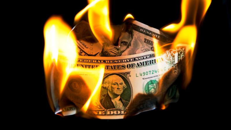 Burning U.S. one and five dollar bills in London in 2011