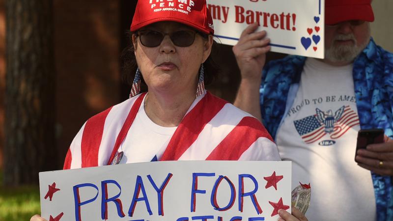 A woman holds a placard in support of Judge Amy Coney Barrett