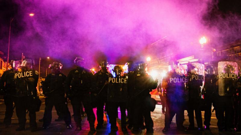 Police officers stand outside 4th District Police Station amid protests