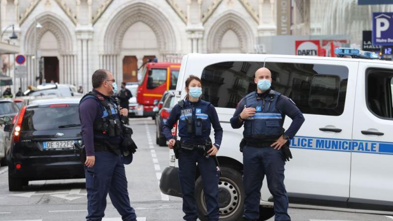 French policemen stand guard the street leading to the Basilica of Notre-Dame de Nice after a knife attack in Nice on October 29, 2020