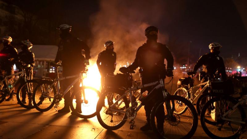 Police officers with bikes near a fire on November 14, 2020