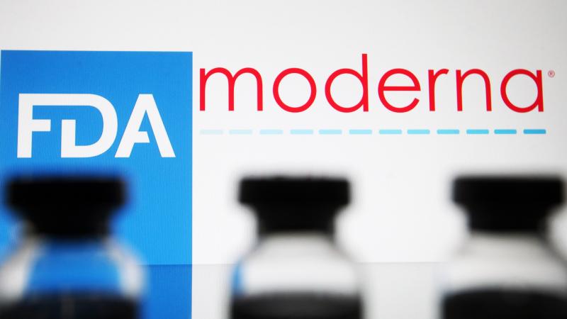 In this photo illustration, vials seen displayed in front of the Food and Drug Administration (FDA) of the United States and Moderna biotechnology company's logos. 