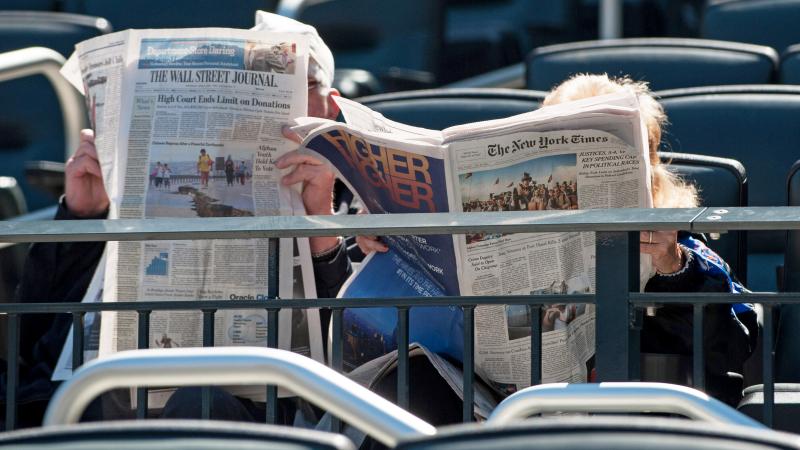 Fans reading the the New York Times and the Wall Street Journal before the game between the Washington Nationals and the New York Mets at Citi Field on April 3, 2014 in the Flushing neighborhood of the Queens borough of New York City.