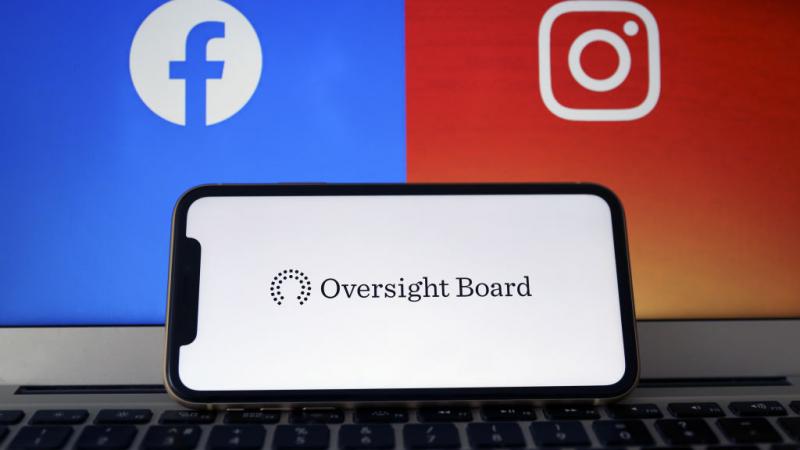 Oversight Board logo seen on phone, with Facebook and Instagram logos in background