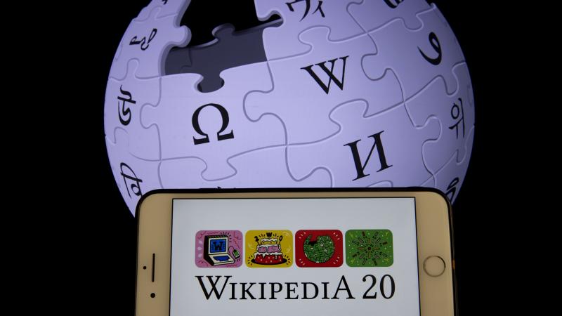 In this illustration photo Wikipedia logos are displayed on a smartphone and a screen in Ankara, Turkey on January 19, 2021.