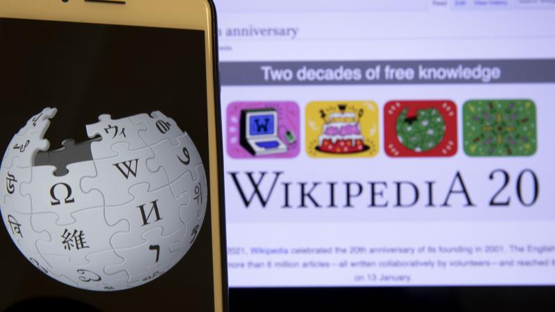 In this illustration photo Wikipedia logo is displayed on a smartphone as Wikipedia website is seen behind, in Ankara, Turkey on January 19, 2021. 