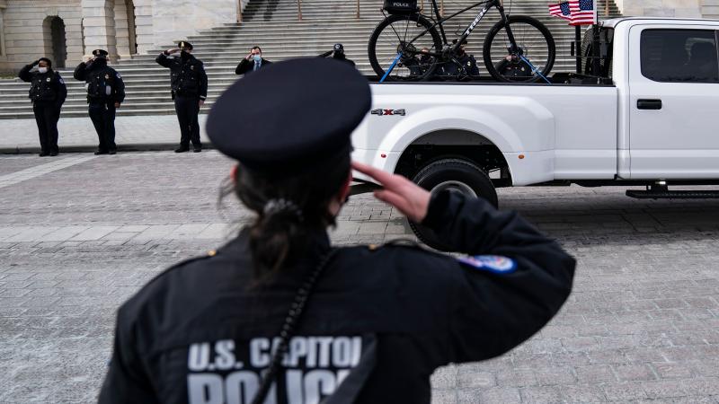 Police officer salutes the bike of U.S. Capitol Police officer Brian Sicknick