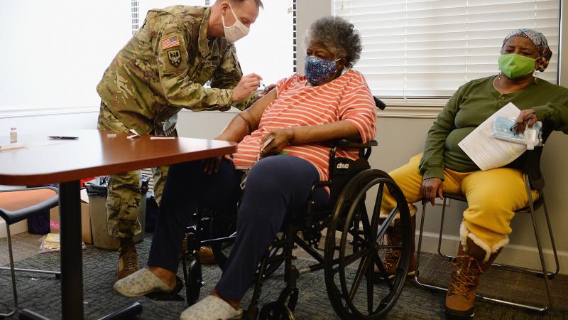 Staff Sergeant Herbert Lins of the Missouri Army National Guard administers the Covid-19 vaccine to a resident during a vaccination event on February 11, 2021 at the Jeff Vander Lou Senior living facility in St Louis, Missouri.