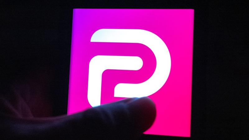 Illustrative image of hand with device showing Parler logo