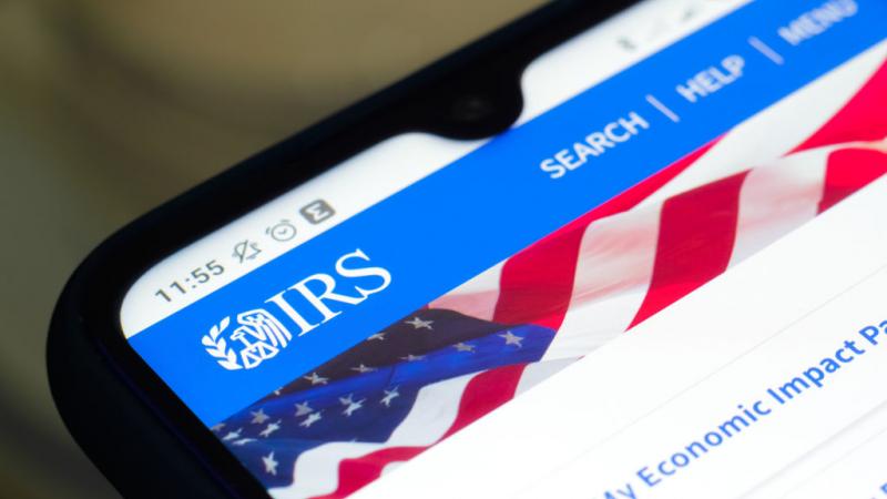 Photo illustration of IRS logo on phone screen