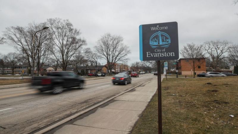 Vehicles drive past sign welcoming people to Evanston, Illinois