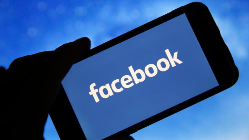 Photo illustration of Facebook logo seen on phone screen