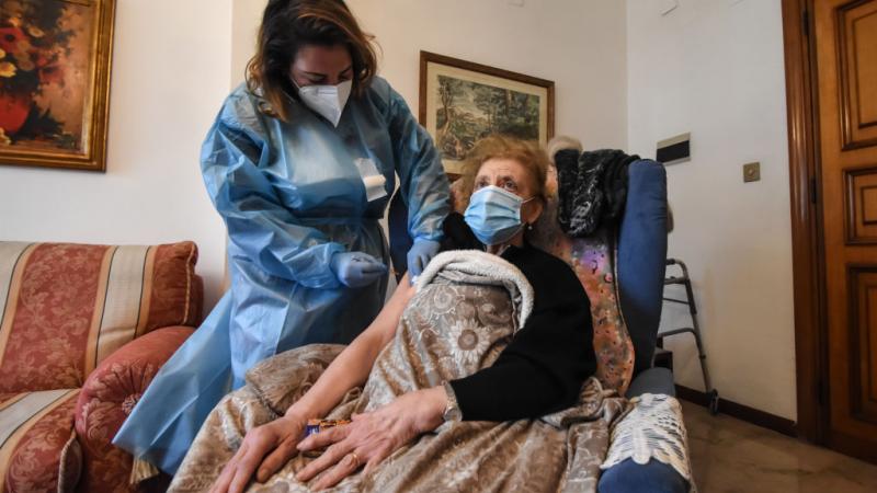 Woman over the age of 80 receives her COVID-19 vaccine in an at home vaccination in Italy.