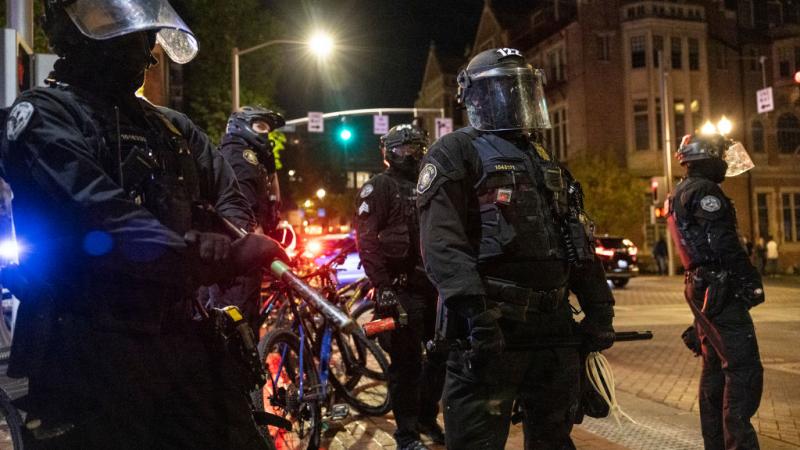  Portland police stand guard as tensions rise with a small group of protesters on April 20, 2021.