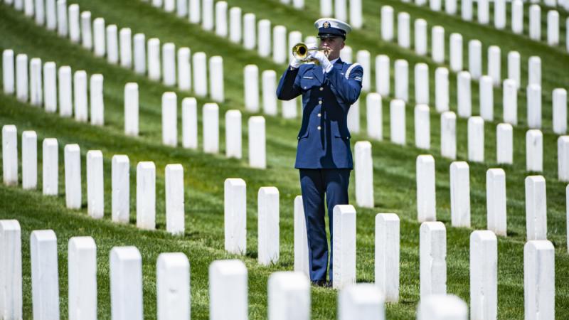A bugler plays taps at Arlington National Cemetery