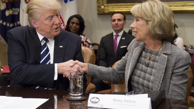 US President Donald Trump shakes hands with Secretary of Education Betsy DeVos during a meeting with teachers, school administrators and parents in the Roosevelt Room of the White House in Washington, DC, February 14, 2017.