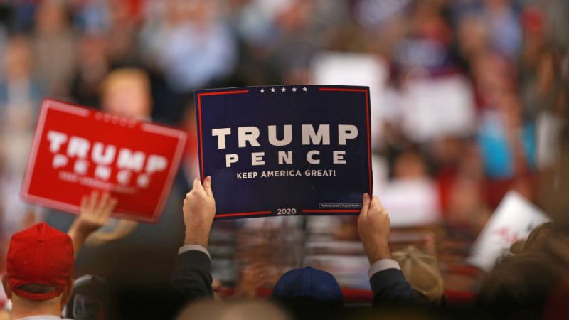 Attendees hold signs as President Trump speaks in Louisiana in 2019
