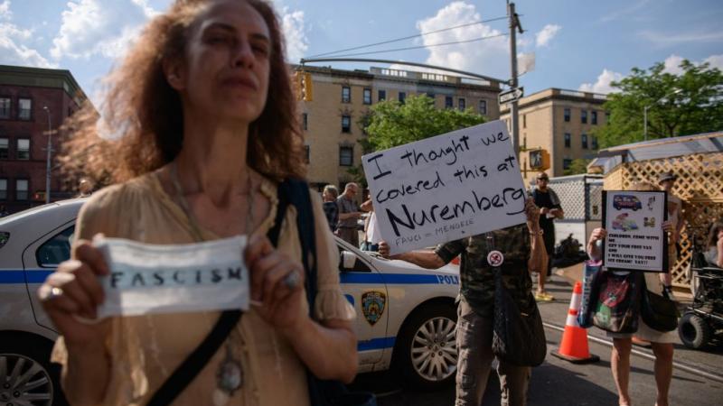 Protestors stand outside the Harlem vaccination site where Dr. Fauci and the First Lady arrived on June 6.