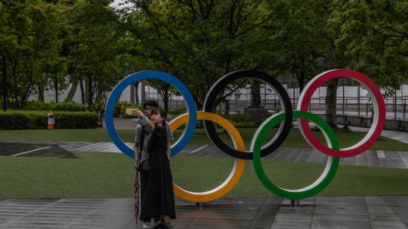 Couple pose in front of Olympics rings