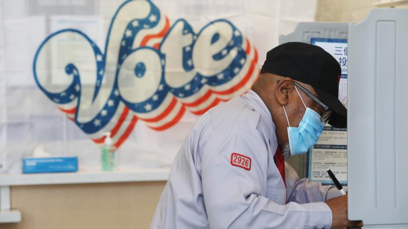 Larry McKinney, fills in his ballot in a booth at the polling place at Boba Guys on Fillmore Street on Tuesday, November 3, 2020 in San Francisco, Calif.