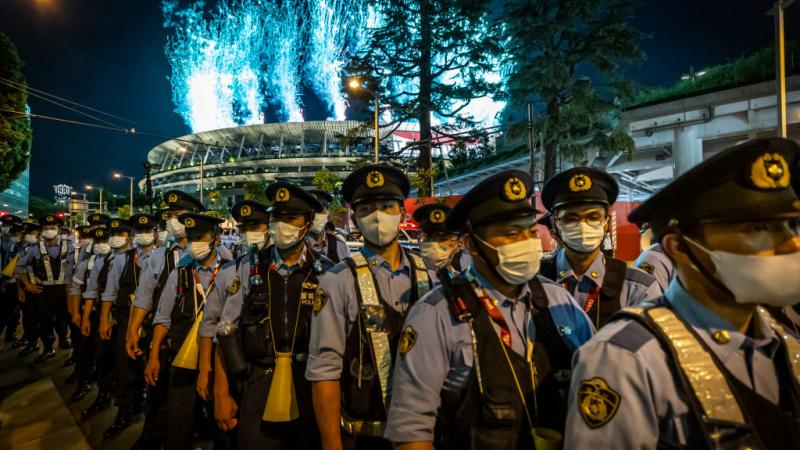  Fireworks are seen as police officers gather to block anti-Olympics protesters during the Opening Ceremony
