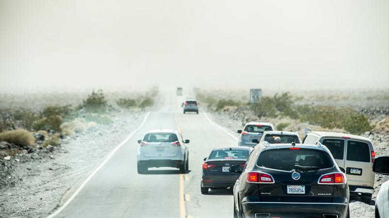 Drivers stop on side of road as a dust storm approaches. 