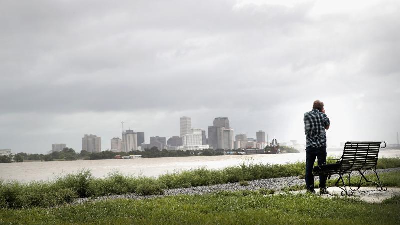 Kevin Hecht takes a picture of the New Orleans skyline from the top of a levee in the Holy Cross neighborhood as rain from the outer bands of Hurricane Barry moves into the area on July 12, 2019 in New Orleans, Louisiana.
