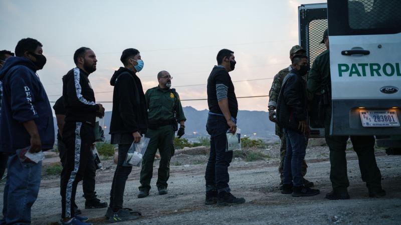 Migrants caught crossing the US-Mexico border are loaded into a transport van by US Border Patrol agents in Sunland Park, New Mexico on July 22, 2021.