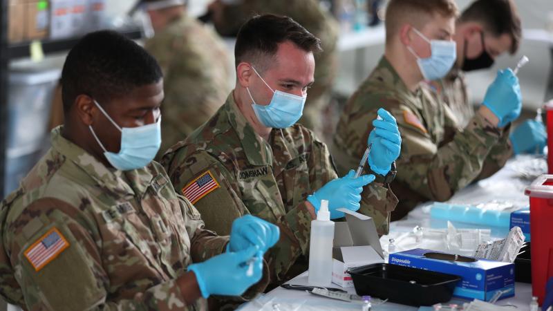 U.S. Army soldiers from the 2nd Armored Brigade Combat Team, 1st Infantry Division, prepare Pfizer COVID-19 vaccines to inoculate people at the Miami Dade College North Campus on March 09, 2021 in North Miami, Florida.