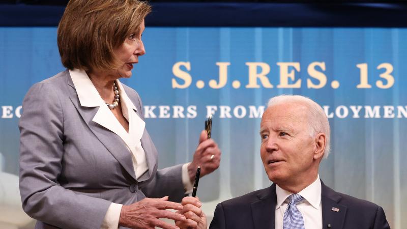U.S. Speaker of the House Nancy Pelosi receives a pen from President Joe Biden after he signed three Congressional Review Act bills into law June 30, 2021 in Washington, DC.