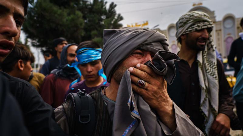 A man watches Taliban violence outside airport in Kabul 