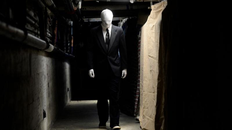 Boulder High School senior Korben Smart walks down a dingy hallway dressed as Slender Man while preparing for a costume check at the Boulder High School Haunted House
