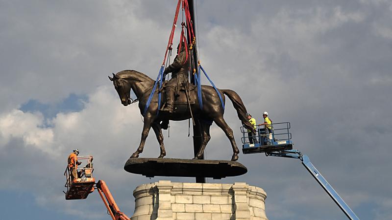 The statue of Confederate General Robert E. Lee is removed from its pedestal on Monument Avenue on September 8, 2021 in Richmond, Virginia.