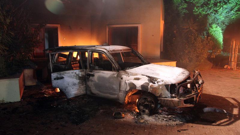 A vehicle and surrounding buildings smolder after they were set on fire inside the US consulate compound in Benghazi late on September 11, 2012.