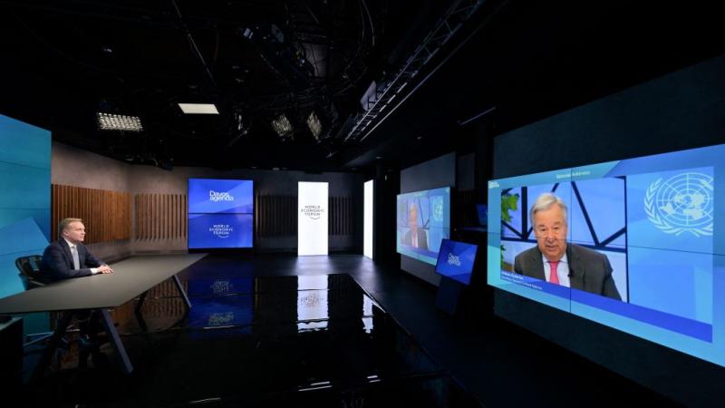 World Economic Forum (WEF) President Borge Brende listen to UN Secretary General Antonio Guterres on a TV screen addressing remotely the WEF Davos Agenda virtual sessions