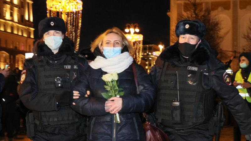 Police detain protester with flowers, Feb. 24, 2022, Moscow, Russia