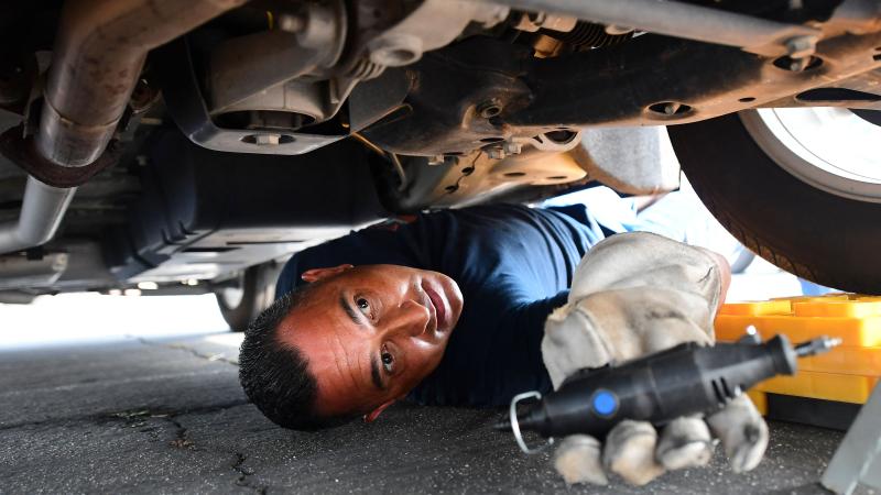 Police officer, catalytic converter, Los Angeles, Calif., July 14, 2021