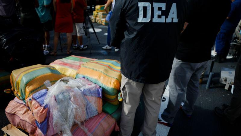 Federal agents next to seized drugs including marijuana, Florida, Nov. 2021