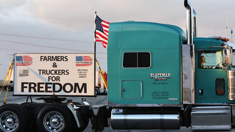A trucker sits in his cab as truck drivers and supporters gather one day before a ‘People’s Convoy’ departs for Washington, DC, to protest COVID-19 mandates on February 22, 2022 in Adelanto, California.