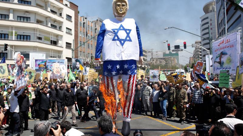Iranian protesters burn an effigy of Donald Trump in an Israeli Flag, Tehran, Iran, June 8, 2018