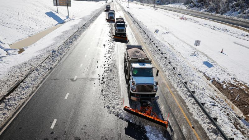 Plow trucks clear I-95 after a major snowstorm