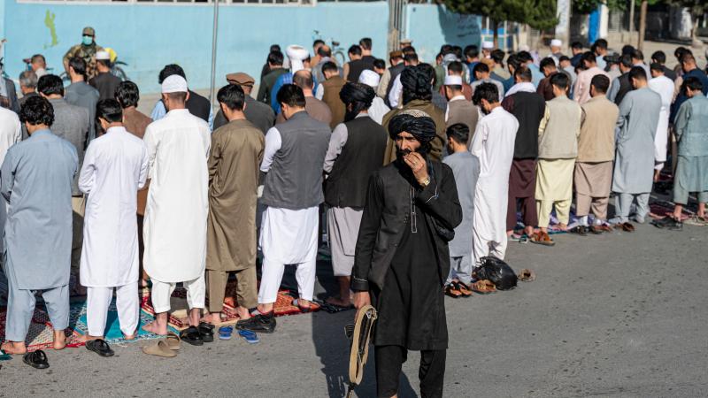 Taliban guards Muslims praying, Kabul, Afghanistan, May 1, 2022