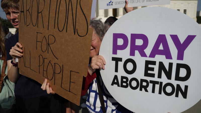 A pro-choice activist tries to block a pro-life activist during a rally in front of the U.S. Supreme Court in response to the leaked Supreme Court draft decision to overturn Roe v. Wade May 3, 2022 in Washington, DC.